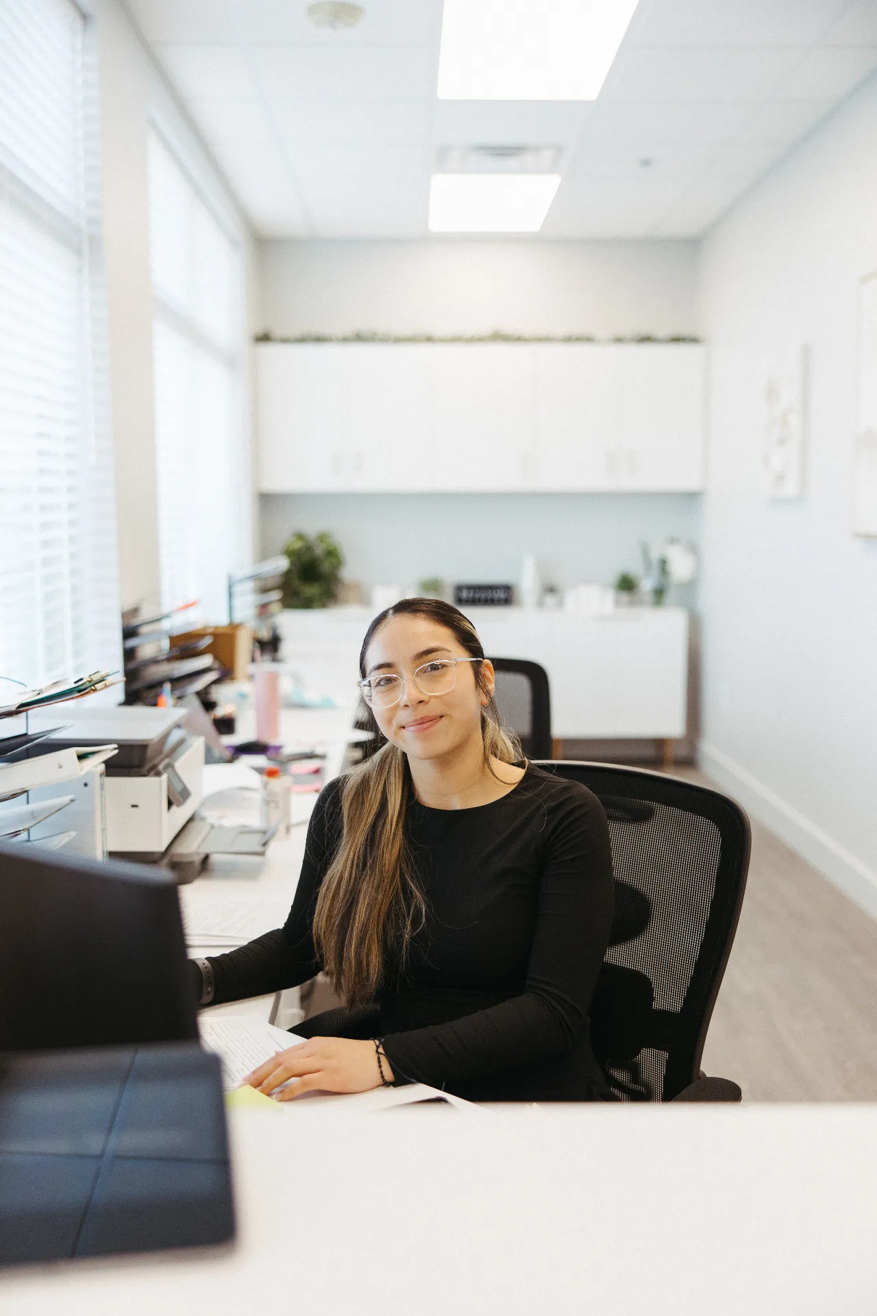 Front desk employee at Encompass Wellness & Aesthetics after receiving BroadBand Light (BBL) Therapy.