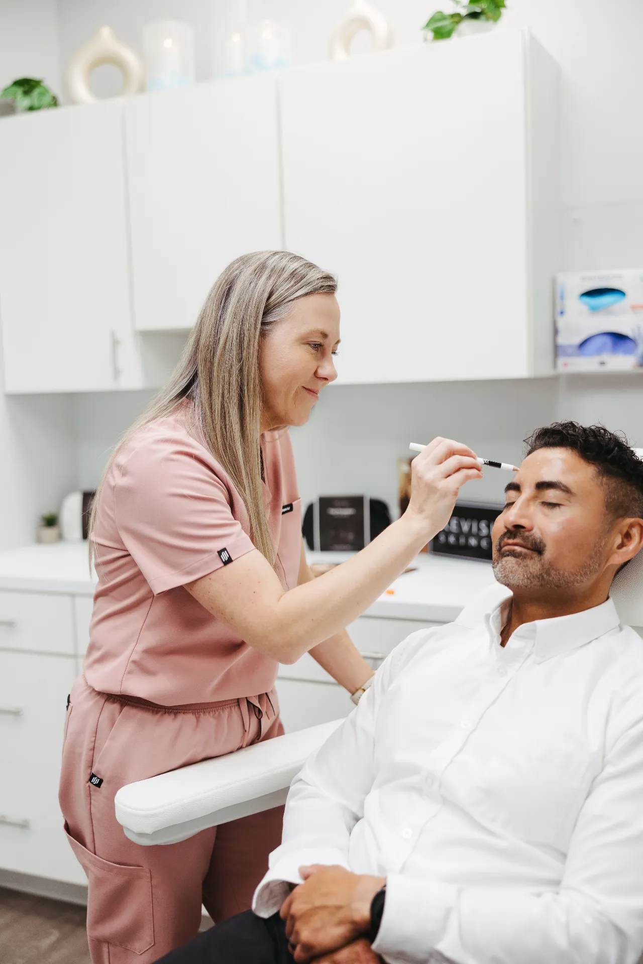 An Encompass Wellness & Aesthetics customer being marked to prepare for an aesthetics service.