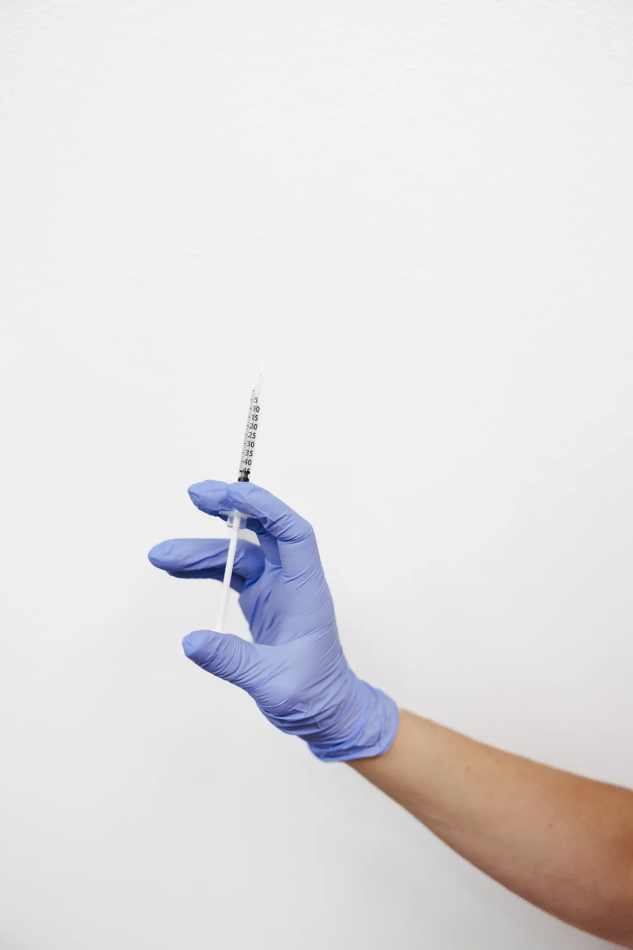 Encompass Wellness provider holding a prepared syringe during the P-Shot PRP injection process