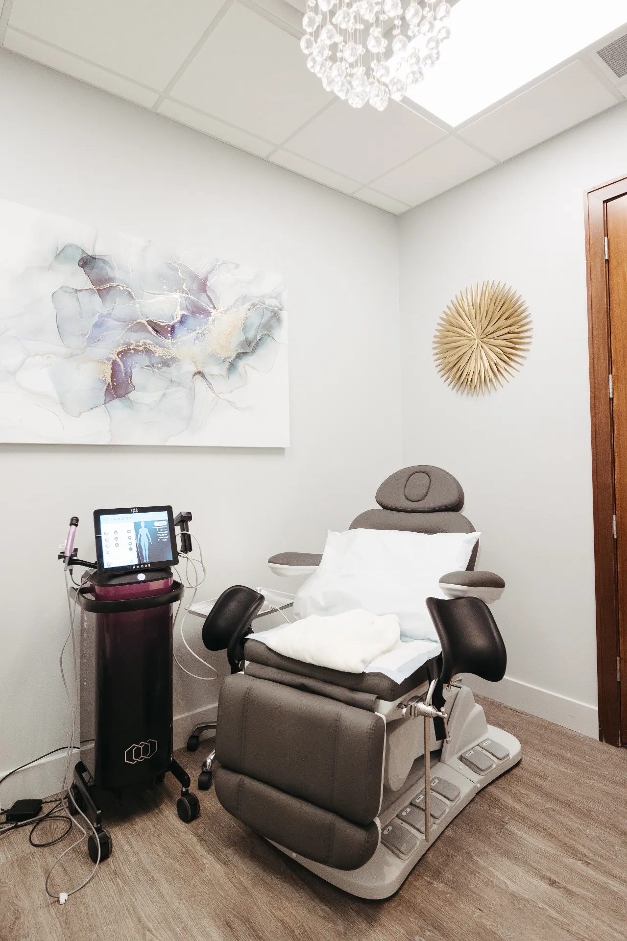 FormaV treatment room at Encompass Wellness showing an InMode machine, reclining patient chair, and warm clinic environment