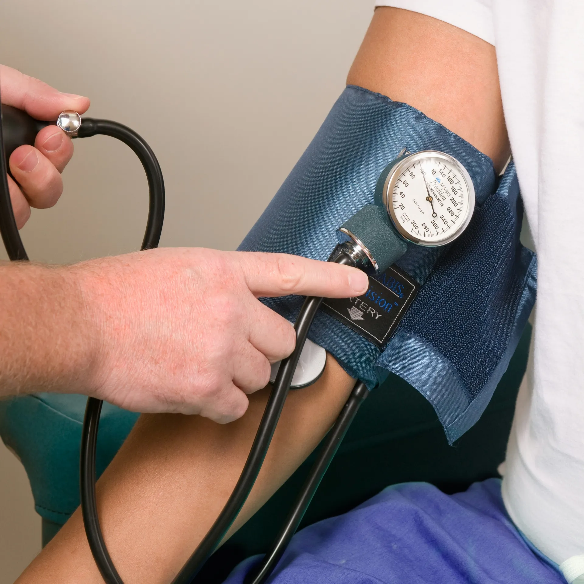 Clinician checking a patient’s blood pressure during an Early Cancer Screening appointment.