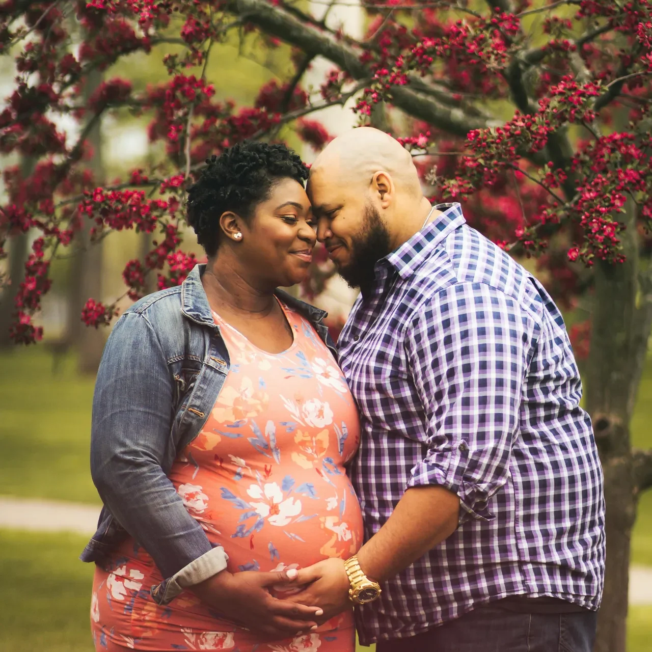 Expectant couple embracing beneath a blooming tree, illustrating Peptide Therapy fertility and reproductive wellness goals
