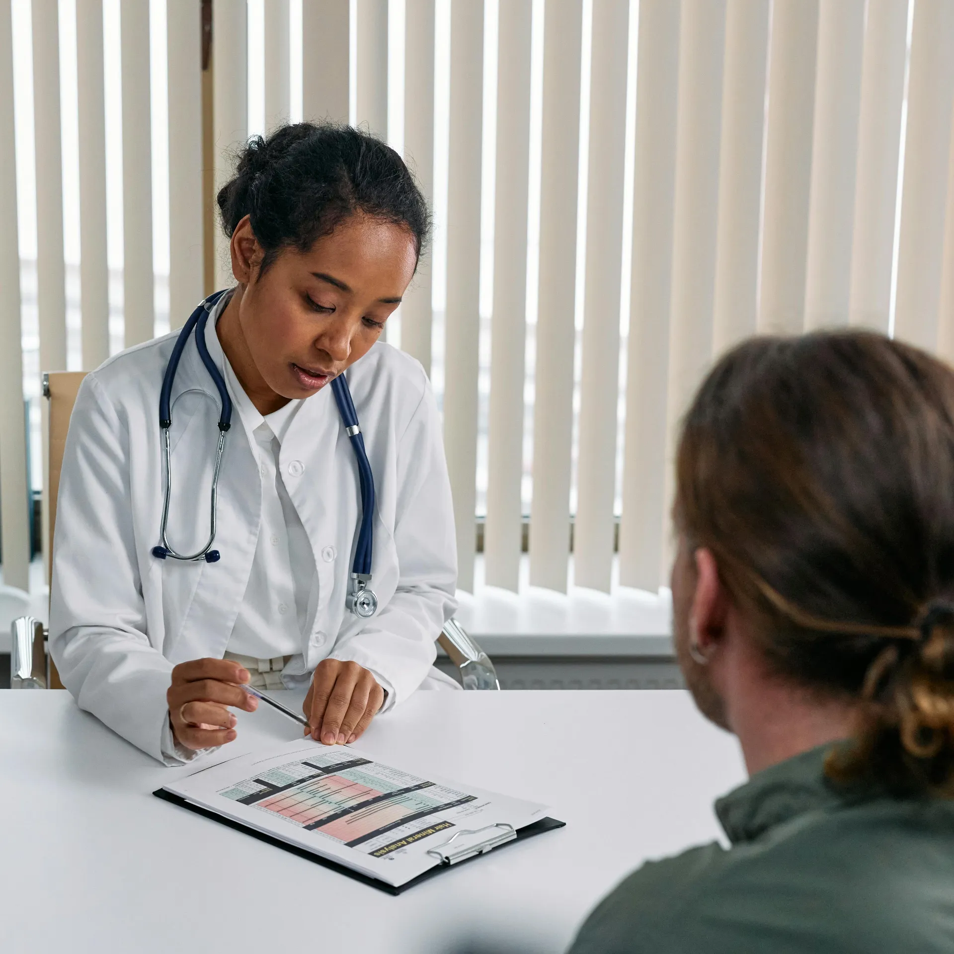 Provider and patient discussing options for Early Cancer Screening in a medical office.