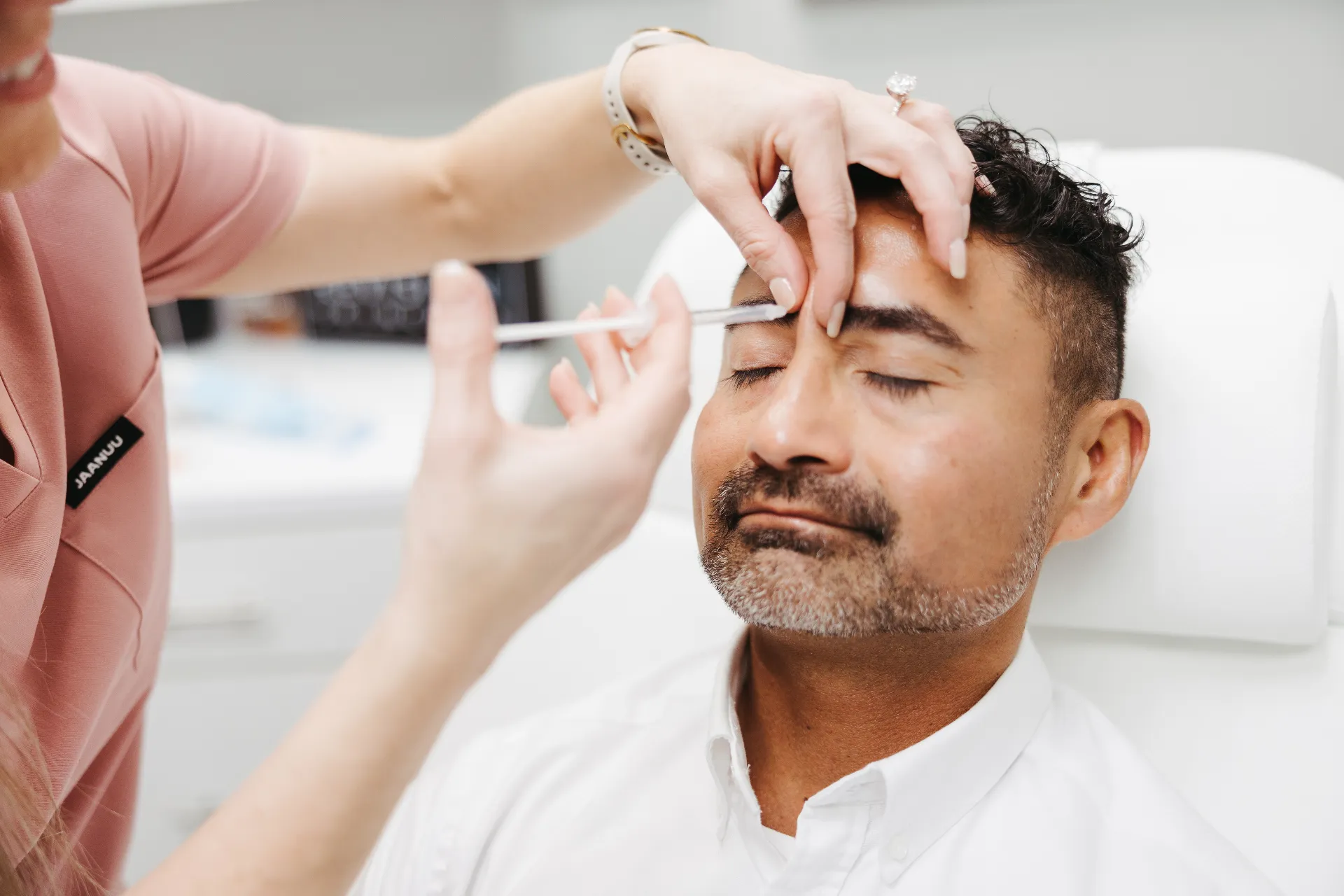 Encompass Wellness provider performing an injection procedure on a male patient in his 50s