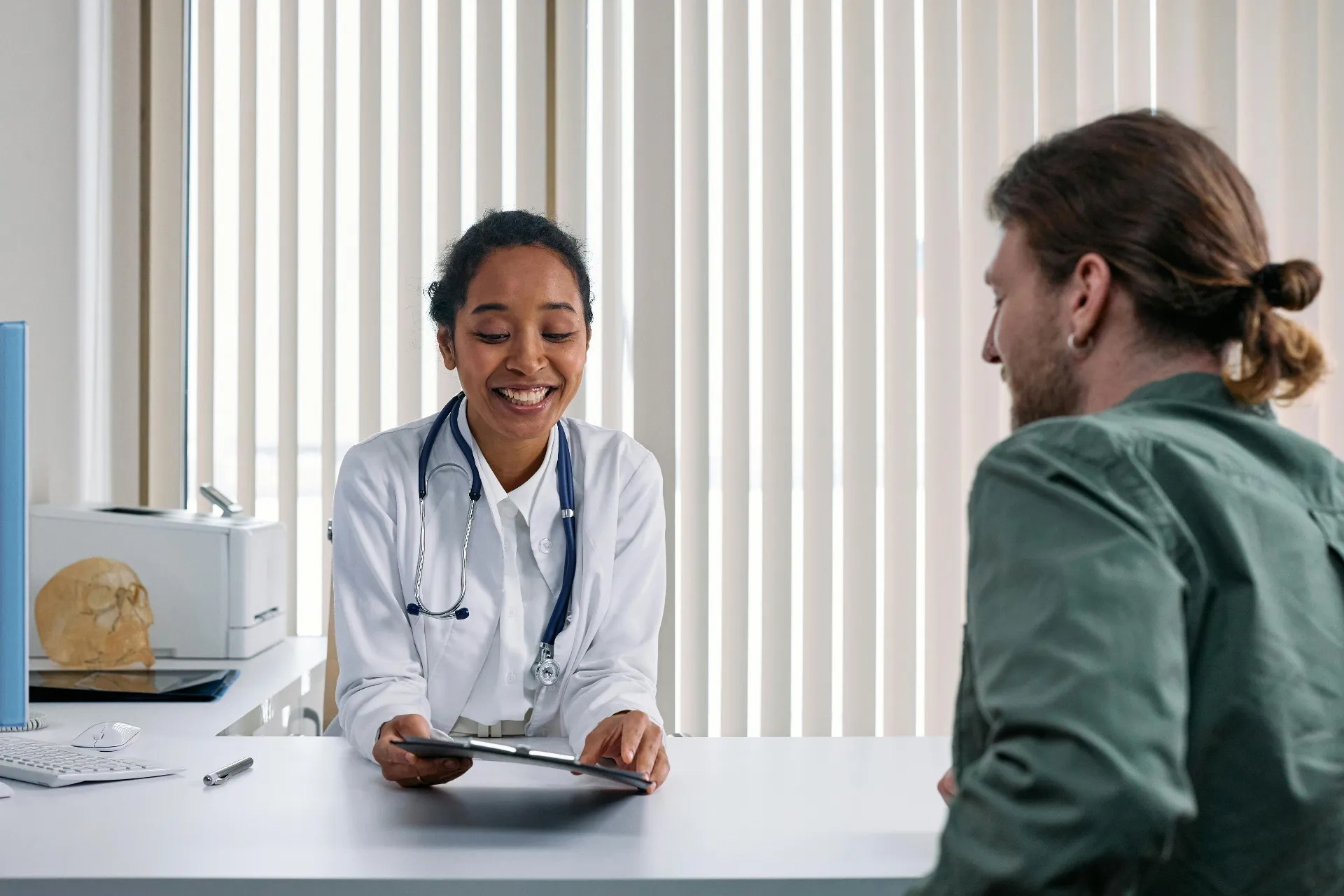 Provider consulting male patient about men's health treatment options in a modern clinic